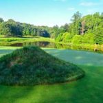 The Preserve at Eisenhower green with grass mound in front of green and lake behind the green